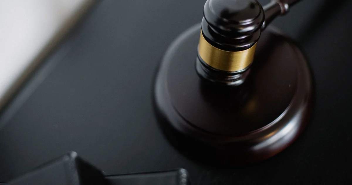Marteau de juge et maison fissurée, illustrant la justice face aux sinistres RGA